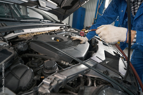 Male working in service center and checking oil pressure © Svitlana