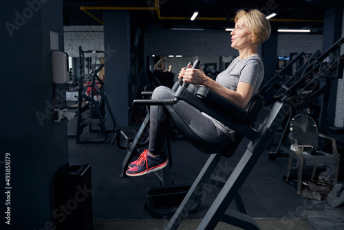 Woman in sportswear using fitness equipment in gym