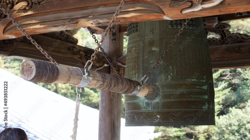 Vidéo Stock Hitting the traditional ancient Japanese bronze bell with a