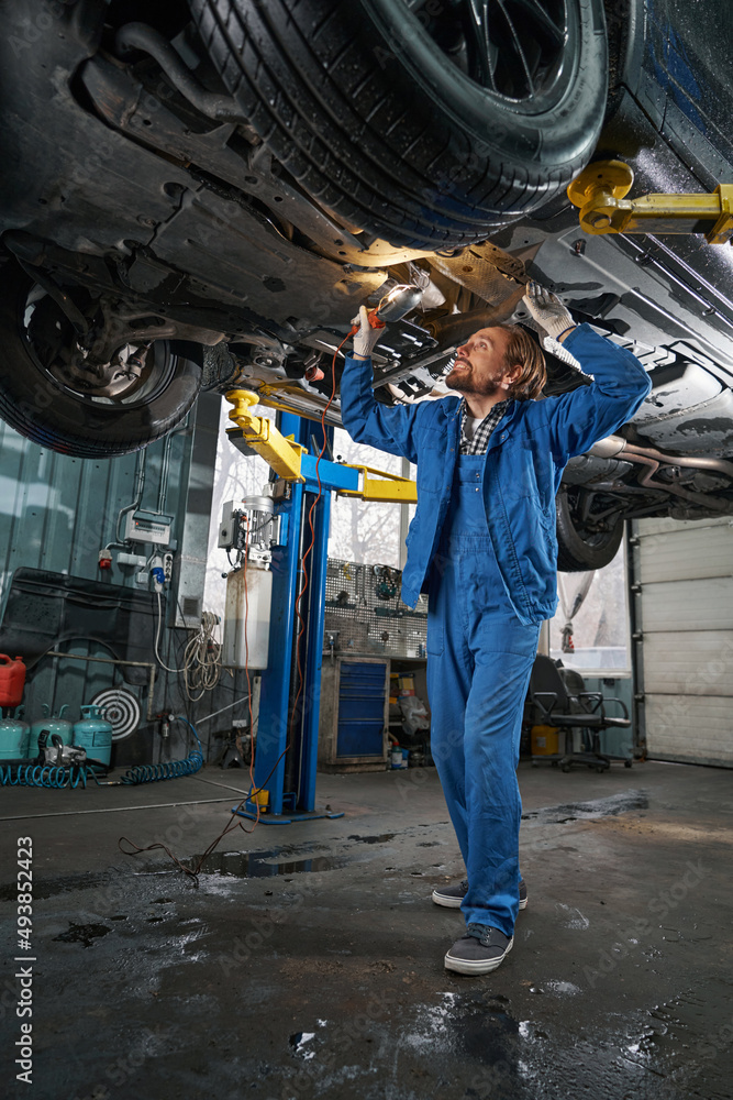 Mechanic holding lamp and performing machine diagnostics Mechanic holding lamp and performing machine diagnostics