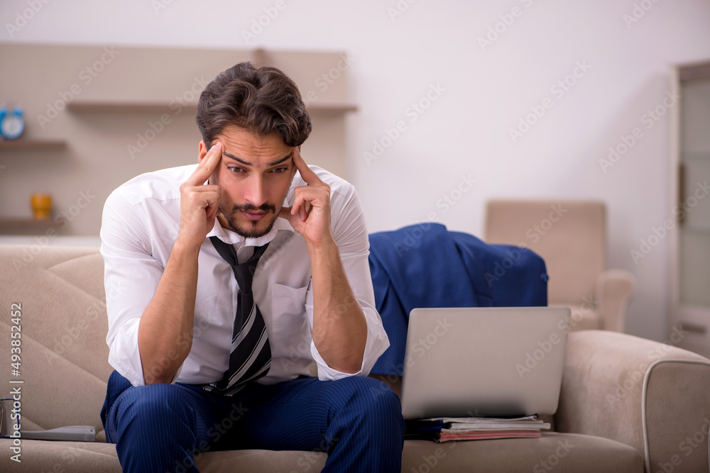 Fototapeta premium Young male employee working from home during pandemic