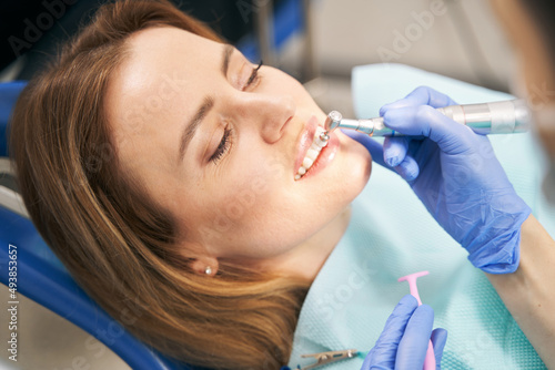 Dentist performing teeth treatment with tooth polisher device