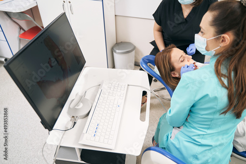 Dentist examining woman teeth with dental intraoral 3D scanner