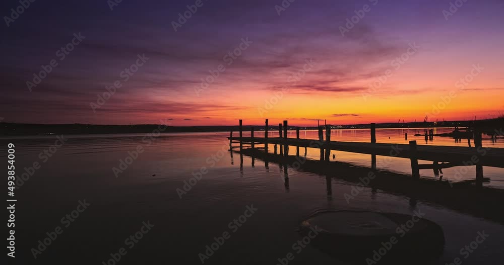 Lake and wooden jetty pier. Scenic sea sunset and beach shore Lake and wooden jetty pier. Scenic sea sunset and beach shore