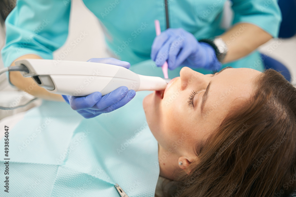 Dentist scanning female teeth with dental 3D scanner Dentist scanning female teeth with dental 3D scanner