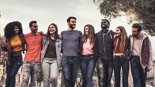фотографія Multiethnic group of people standing together and walking outdoors arm on should