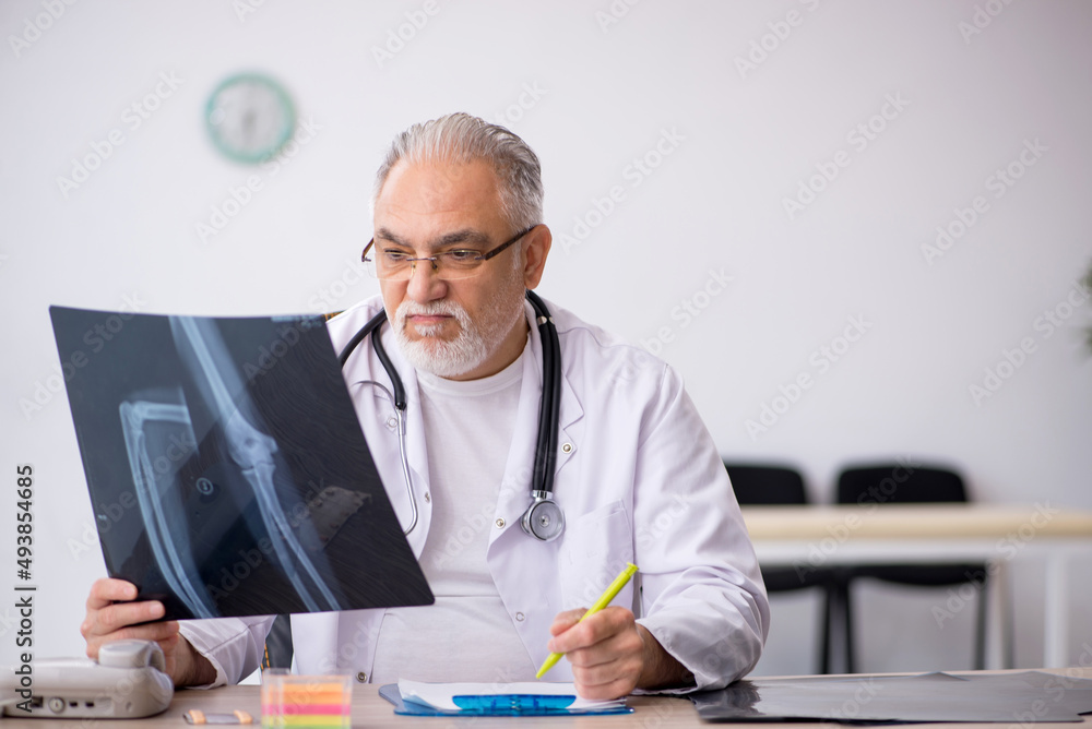 Old male doctor radiologist working in the clinic Old male doctor radiologist working in the clinic