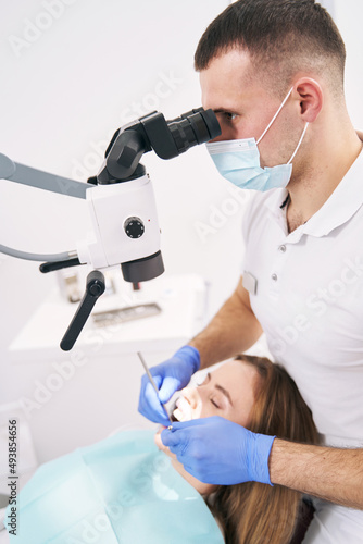 Dentist performing dental treatment with microscope in clinic © Viacheslav Yakobchuk
