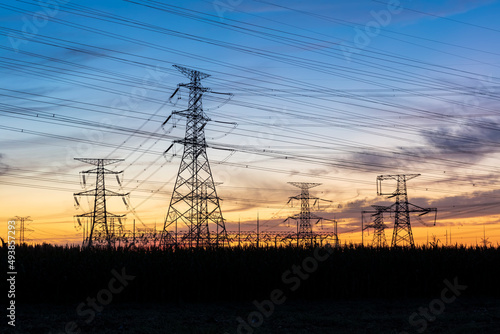 In the evening, the silhouette of high voltage towers