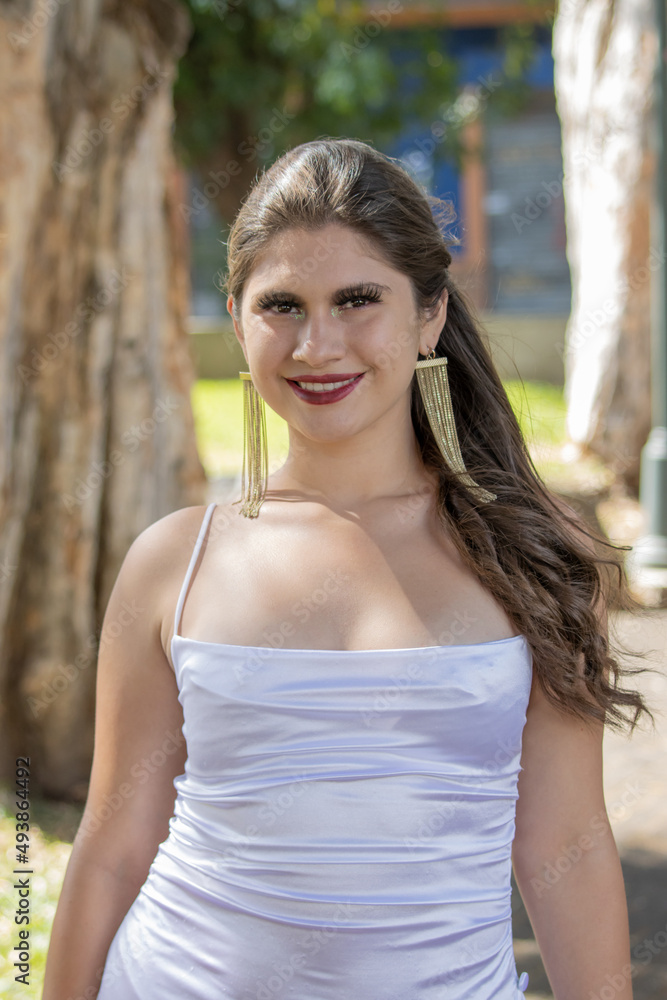 young latina woman in white dress in San Jose Costa Rica on a sunny and windy summer day. sexy free and successful college woman. copy space and background blur. young latina woman in white dress in San Jose Costa Rica on a sunny and windy summer day. sexy free and successful college woman. copy space and background blur.