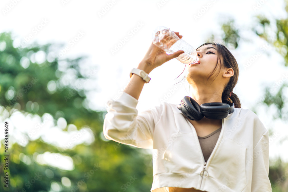Portrait sport asian beauty body slim woman drinking water from a bottle while relax and feeling fresh on green natural background at summer green park.Healthy lifestyle concept Portrait sport asian beauty body slim woman drinking water from a bottle while relax and feeling fresh on green natural background at summer green park.Healthy lifestyle concept