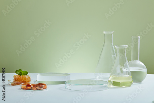 A front view of honey and turmeric extract with laboratory equipment in green background for advertising