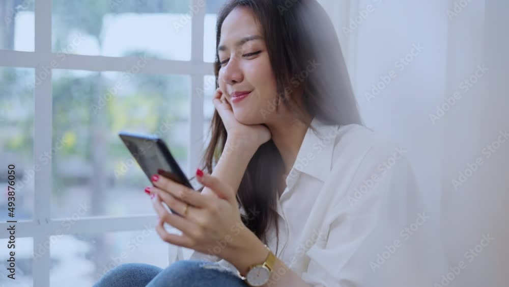 attractive casual asian female adult woman friend conversation positive emotion sit on window bench with pleasure and peaceful smiling comunication,asia woman speaking via smartphone at home daytime attractive casual asian female adult woman friend conversation positive emotion sit on window bench with pleasure and peaceful smiling comunication,asia woman speaking via smartphone at home daytime
