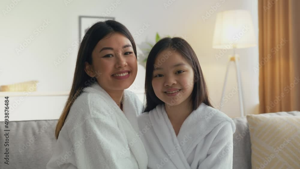 Portrait of happy asian mother and daughter smiling to camera and rubbing noses, sitting together at home, zoom in Portrait of happy asian mother and daughter smiling to camera and rubbing noses, sitting together at home, zoom in