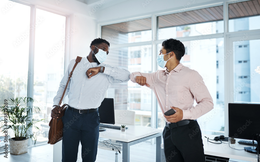 Fototapeta premium A new greeting adopted during the pandemic. Shot of two businessmen bumping elbows in an office.