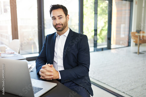 My passion lies with this business. Portrait of a businessman working on a laptop in a modern office.