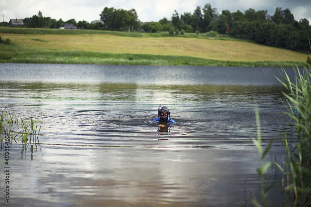 A scuba diver in a wet suit prepares A scuba diver in a wet suit prepares