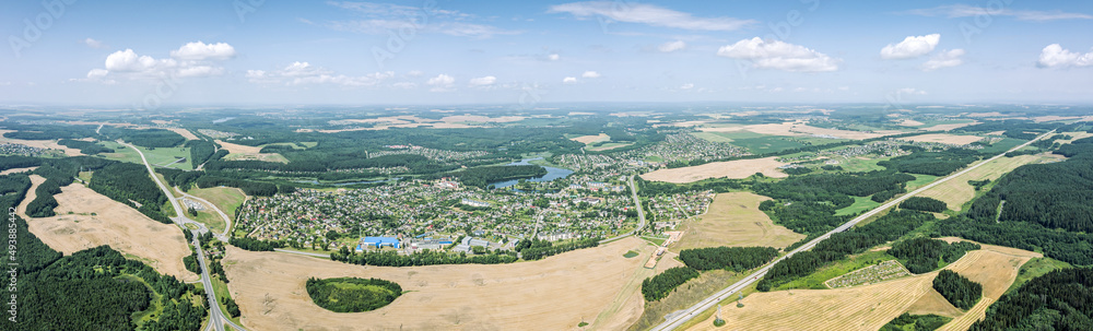 panoramic rural landscape on a hot summer day. aerial view of farm land and freeway roads.