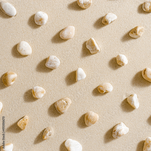 Pattern with close up pebble sea stones on sand texture. Layout from natural stone neutral natural tones. Minimal style sandy background