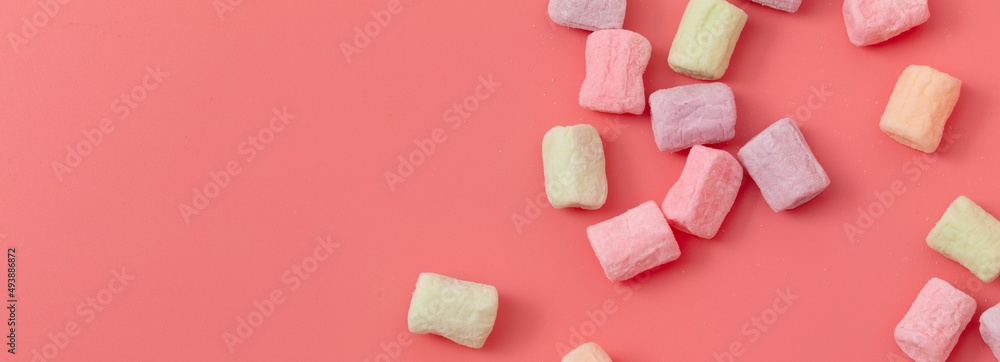 Multicolored candies on a pink background. Close-up Multicolored candies on a pink background. Close-up