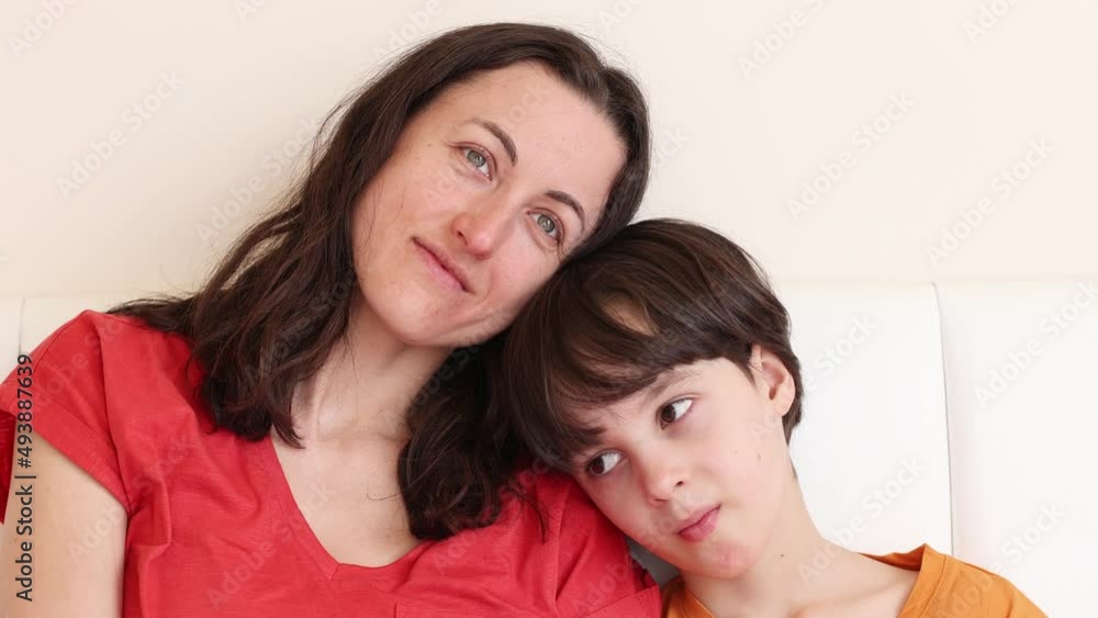 A child with mom sit on the bed, a woman and a boy in pajamas, a woman hugs her son, morning with mom A child with mom sit on the bed, a woman and a boy in pajamas, a woman hugs her son, morning with mom