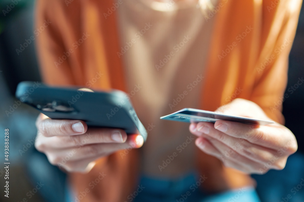 Online payment, Close up - Hands of woman holding a credit card and using smart phone for online shopping Online payment, Close up - Hands of woman holding a credit card and using smart phone for online shopping