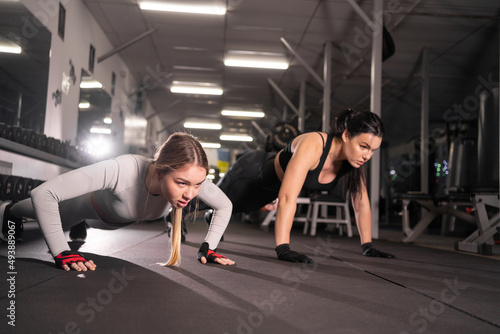 two happy young women in the gym doing push up exercise.Healthy lifestyle, gymnastics concept