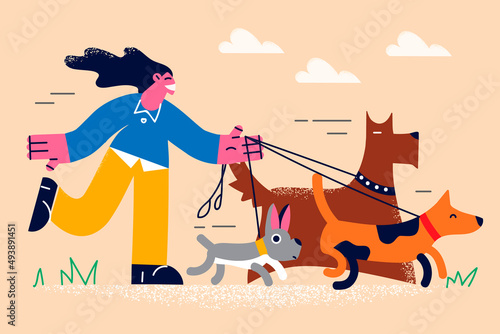 Smiling girl walking dogs on lead outdoors 