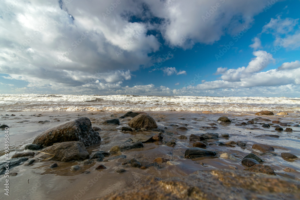 seascape with sea waves crashing on the shore and exploding, beautiful blue skies and white clouds over the sea, Vidzeme rocky seashore, Salacgriva rural area, Latvia seascape with sea waves crashing on the shore and exploding, beautiful blue skies and white clouds over the sea, Vidzeme rocky seashore, Salacgriva rural area, Latvia