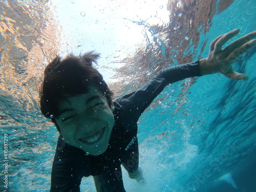 Little boy having fun playing underwater in the pool happy smile
