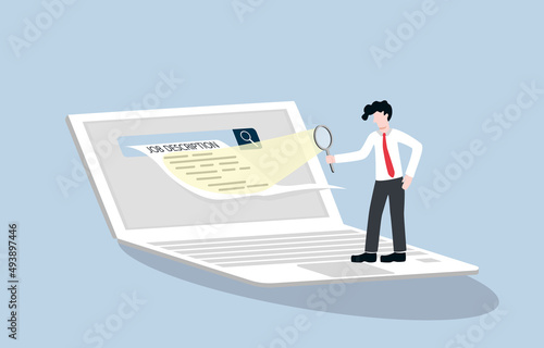 Reading job description carefully, finding the right job concept. Unemployment person holding magnifying glass to look at job description hard copy which come out of laptop screen.