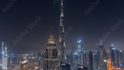 Aerial view of tallest towers in Dubai Downtown skyline and highway night timelapse.