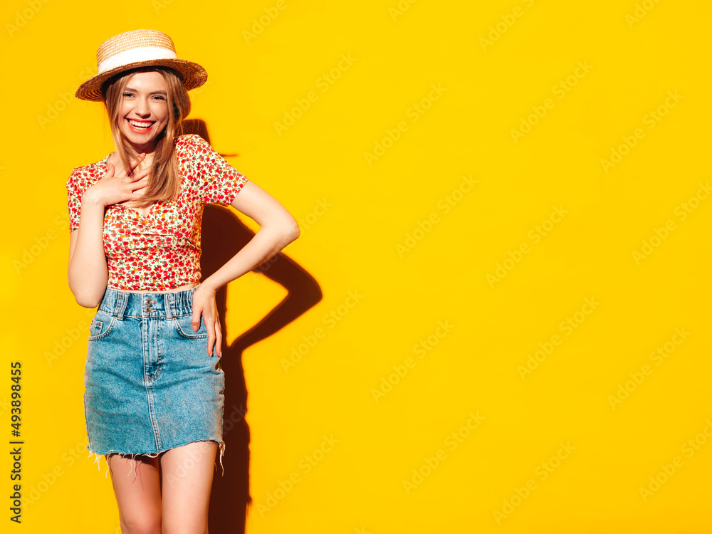 Portrait of young beautiful smiling blond female in trendy summer clothes. carefree woman posing near yellow wall in studio. Positive model having fun indoors. Cheerful and happy. In hat Portrait of young beautiful smiling blond female in trendy summer clothes. carefree woman posing near yellow wall in studio. Positive model having fun indoors. Cheerful and happy. In hat