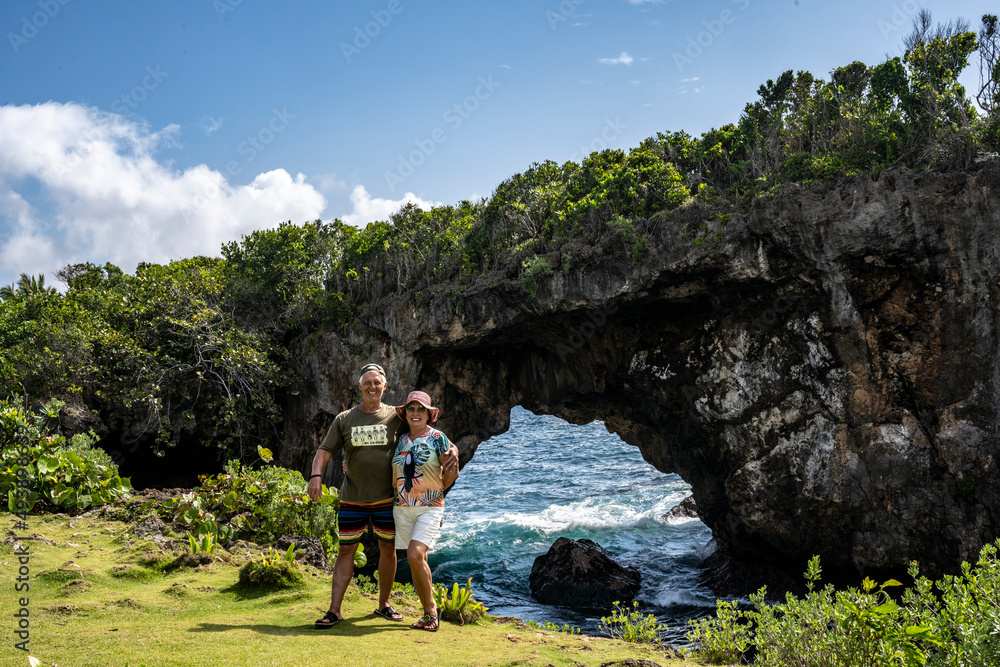 a man and a woman against the backdrop of a grotto in the rock against the backdrop of the sea in the Dominican Republic 