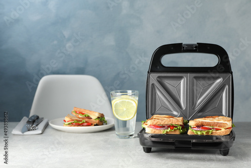 Bilde på lerret Modern grill maker with sandwiches and breakfast served on grey table