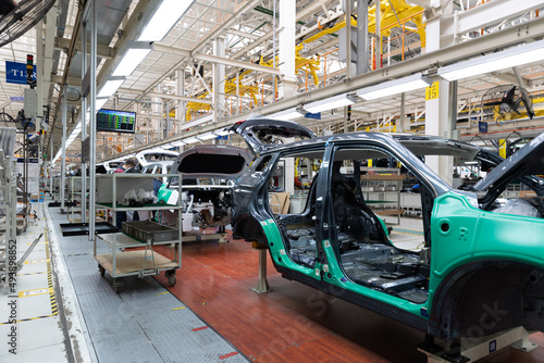 Photo of automobile production line. Welding car body. Modern car assembly plant. Auto industry. Interior of a high-tech factory