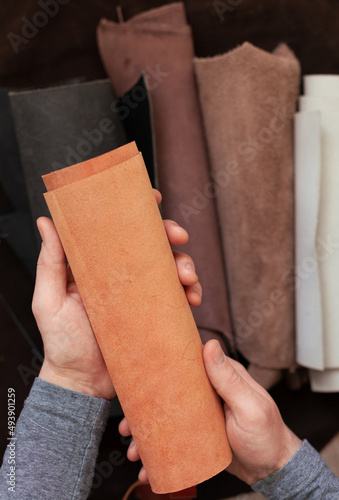 Professional crafter choosing cow leather in roll for making leather items