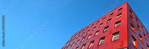 Multi-storey red building standing against blue sky background