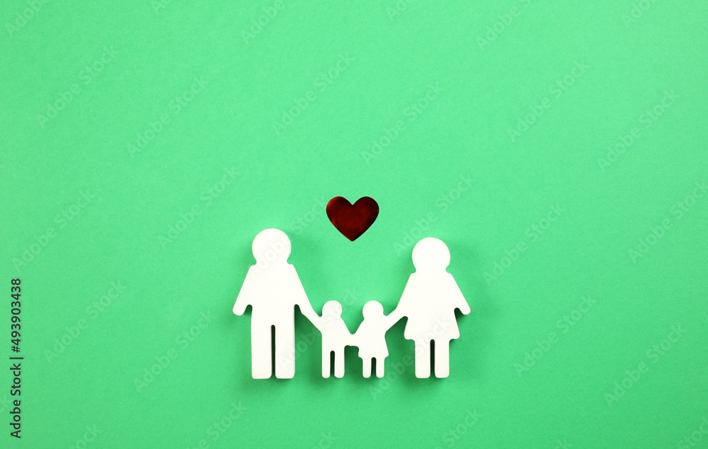 Family figure and red heart on green background, flat lay Family figure and red heart on green background, flat lay