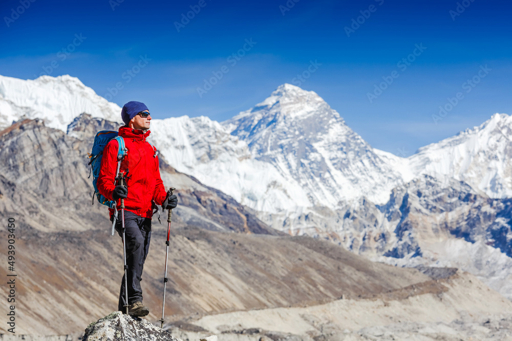 Active hiker hiking, enjoying the view, looking at Himalaya mountains landscape. mountaineering sport lifestyle concept
