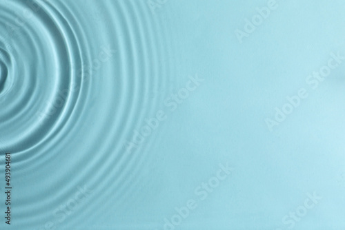 Closeup view of water with circles on turquoise background. Space for text © New Africa