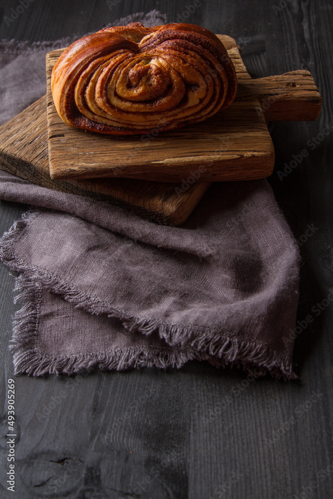 Fresh sweet homemade cinnamon rolls. Svedish cuisine. Dark wood background.
