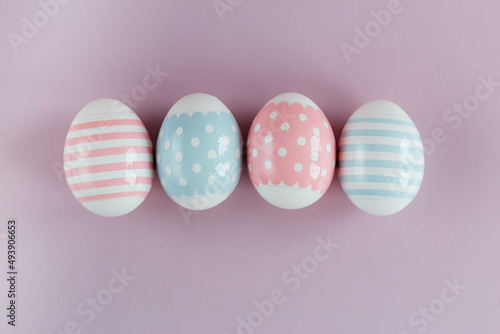 Easter eggs in pastel colors with a pattern on a pink background.