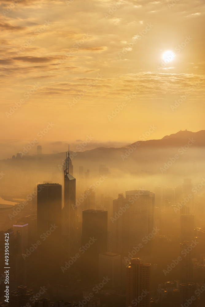 Skyscraper in downtown district of Hong Kong city in fog under sunrise