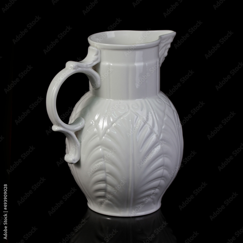 antique white porcelain vase in on a black isolated background. antique ceramic vase with stucco