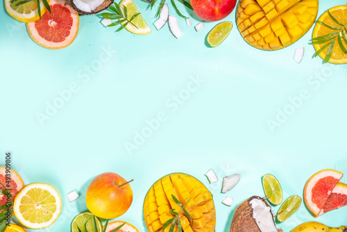 Fototapeta Naklejka Na Ścianę i Meble -  Summer fruits background. Various tropical fruits on turquoise background - mango, coconut, apples, avocado, lemon, orange, grapefruit, pineapple, with palm leaves. Colorful frame, banner flatlay