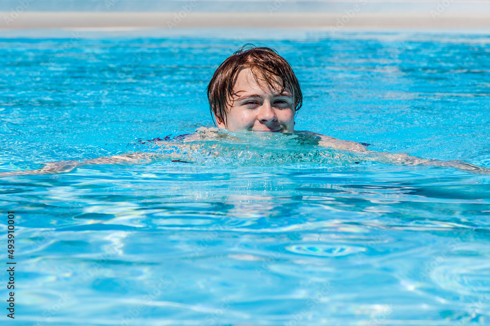 cute handsome teenage boy swims in the pool cute handsome teenage boy swims in the pool