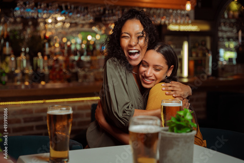 Female friends hugging each other in restaurant