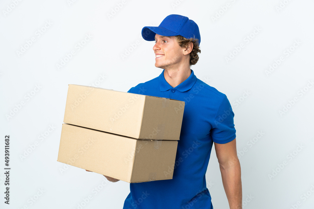 Delivery man over isolated white background looking to the side and smiling Delivery man over isolated white background looking to the side and smiling