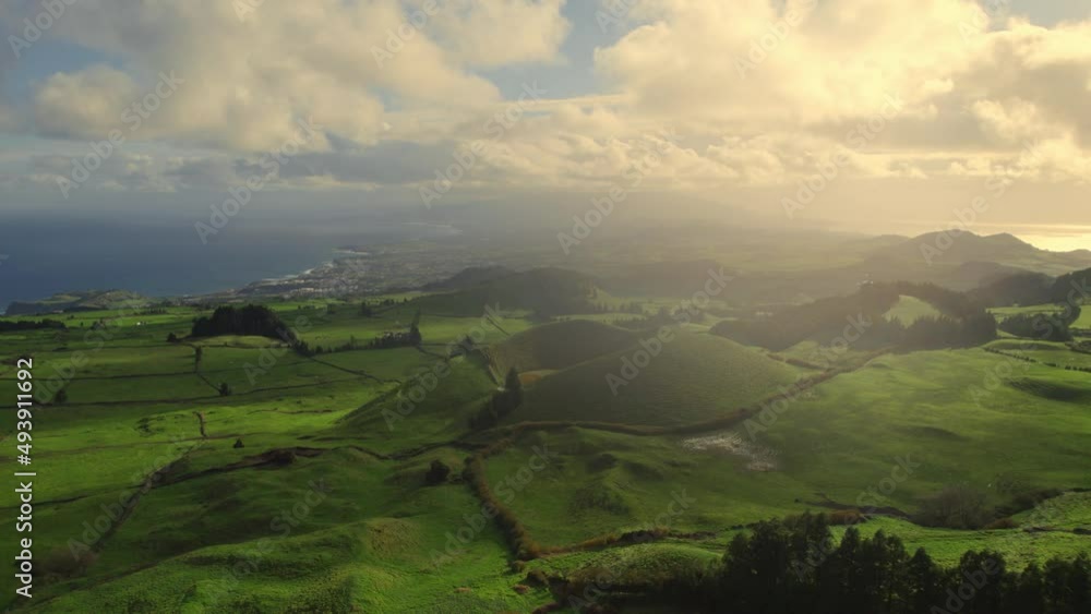 aerial view of lush green grassy hills and volcanic caldera on the Azores island of Sao Miguel, drone flying above rolling fields of Azores archipelago aerial view of lush green grassy hills and volcanic caldera on the Azores island of Sao Miguel, drone flying above rolling fields of Azores archipelago
